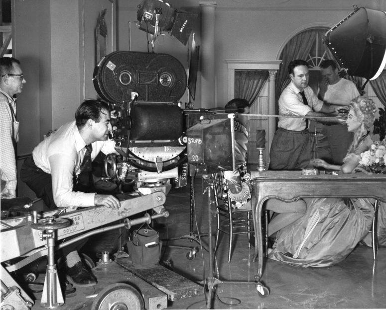 Shooting a commercial for his New York-based firm MPO Videotronics in the early 1960s, Hirschfeld checks his frame. Behind him is operator Sol Roizman. Pulling tape is Tony Brooke.