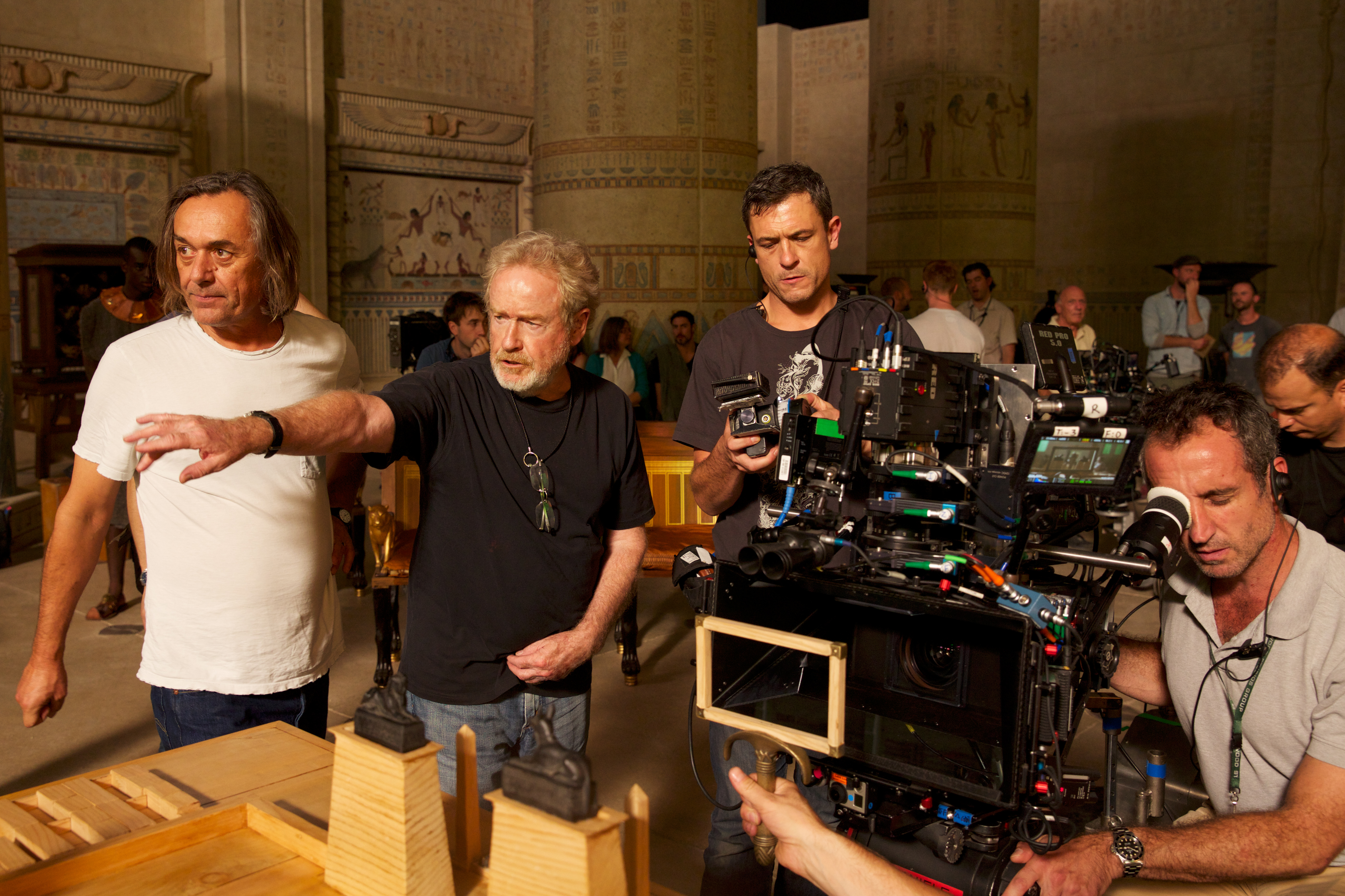 Director Ridley Scott (second from left) sets up a scene with Dariusz Wolski, ASC (left), during filming of Exodus: Gods and Kings. (Credit: Kerry Brown/20th Century Fox)