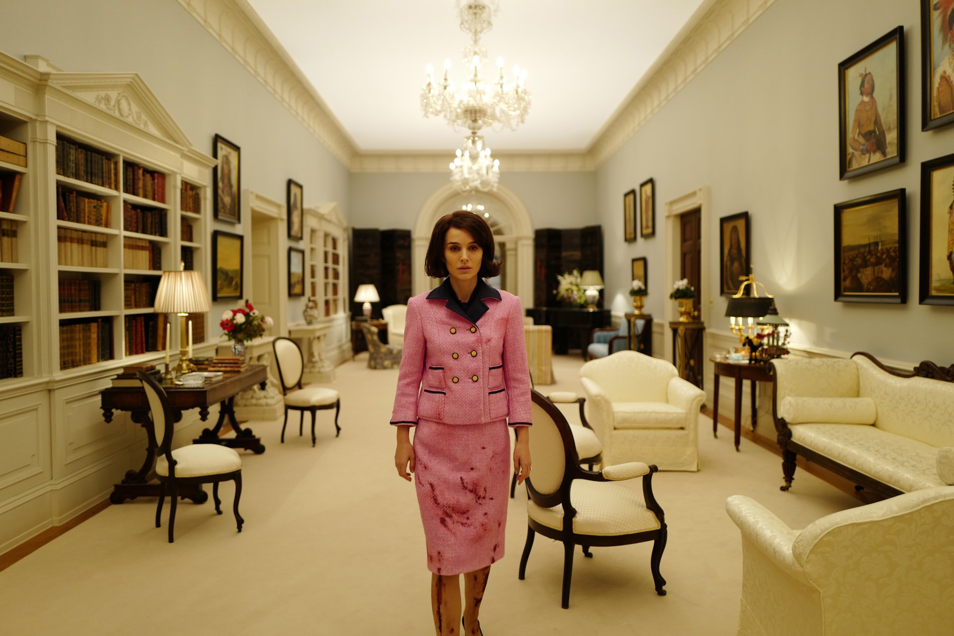Natalie Portman stands in a White House set with a luminous ceiling