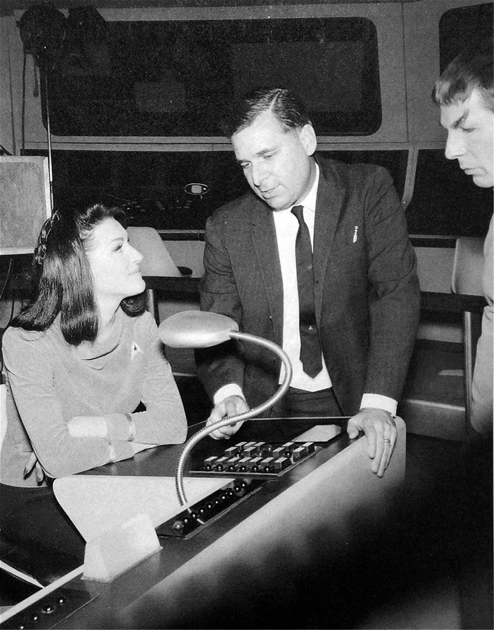 On the bridge set, Trek creator Gene Roddenberry is flanked by Majel Barrett and Leonard Nimoy while filming the first series pilot 